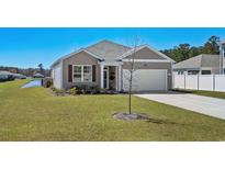 Charming single-story home with well-manicured lawn, attached garage, and lovely curb appeal at 409 Samara Dr., Longs, SC 29568