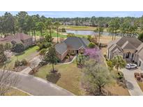 Stunning aerial view of a brick home on a golf course with mature trees and beautiful landscaping at 4222 Congressional Dr., Myrtle Beach, SC 29579