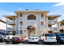 Inviting condo exterior with covered balconies, neutral tones, and ample parking, offering a glimpse of comfortable living at 4234 Pinehurst Circle # L1, Little River, SC 29566