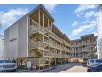 Beautiful multi-level beach condo with outdoor stairs and wood facade near the ocean and under sunny skies at 4305 S Ocean Blvd. # 301, North Myrtle Beach, SC 29582