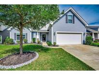 Charming home with light blue siding, well-maintained lawn and mature landscaping at 4437 Marshwood Dr., Myrtle Beach, SC 29579