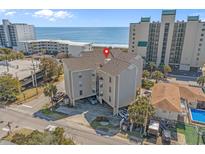 Coastal condo with parking featuring beige siding and a glimpse of the ocean at 4500 S Ocean Blvd. # 9-B, North Myrtle Beach, SC 29582