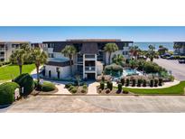 Exterior view of a condo building with pool and palm trees near the ocean at 5601 N Ocean Blvd. # C-311, Myrtle Beach, SC 29577