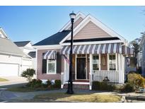 Charming single-Gathering home with a black front door and a striped awning at 676 Johnson Ave., Myrtle Beach, SC 29577