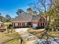 Charming brick home with a well-manicured lawn and a spacious driveway at 749 Club Circle, Pawleys Island, SC 29585