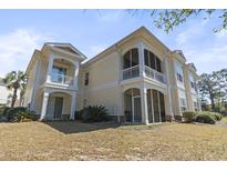 The exterior of this yellow home has large screened porches and small balconies at 77 Tern Pl. # 202, Pawleys Island, SC 29585