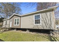 Exterior of home with beige siding, white trim, a small porch, and visible underpinning at 909 Pine Thicket St., Myrtle Beach, SC 29577