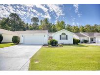 Charming single-story home featuring a manicured lawn, attached garage, and a vibrant red front door at 1161 Ganton Way, Myrtle Beach, SC 29588