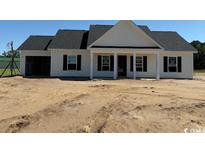 New construction home features a charming white exterior, black shutters, and an attached two-car garage at 1284 Highway 45, Loris, SC 29569