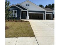 Charming home featuring a three-car garage, manicured lawn, and a classic, inviting facade at 191 Glengrove Lane, Murrells Inlet, SC 29576