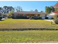 Charming single-story brick home with a well-maintained lawn and attached garage at 4661 Redwood Dr., Myrtle Beach, SC 29588