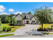 Beautiful single-story home featuring a white brick facade, dark shutters, and a well-manicured lawn at 1004 Bufflehead Dr., Conway, SC 29526