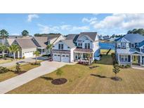 Beautiful two-story home boasts a two-car garage and lush landscaping, set against a picturesque waterfront backdrop at 1055 Fiddleway Way, Myrtle Beach, SC 29579