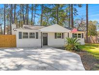 Charming, renovated single-story home with a white brick facade, new driveway, and manicured landscaping at 746 Gumbo Limbo Ln., Myrtle Beach, SC 29579