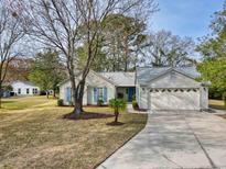 Charming single-story home with blue shutters, two-car garage, and mature landscaping at 1001 Cardinal Ct., Murrells Inlet, SC 29576