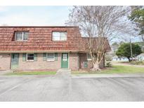 Cozy brick townhouse featuring a charming red roof, green door, and windows at 1025 Carolina Rd. # O4, Conway, SC 29526