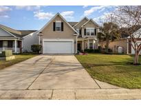 Charming two-story home featuring a well-manicured lawn and a spacious two-car garage on a sunny day at 1268 Brighton Ave., Myrtle Beach, SC 29588