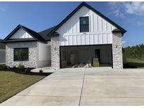 Charming home featuring a stone and white siding exterior, black trim, and an attached two-car garage at 144 Sago Palm Dr., Myrtle Beach, SC 29579