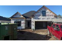 New construction home exterior with covered entrance and attached garage under a clear, blue sky at 144 Sago Palm Dr., Myrtle Beach, SC 29579