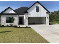 Charming exterior of a home featuring a modern design with stone accents and a spacious two-car garage at 144 Sago Palm Dr., Myrtle Beach, SC 29579