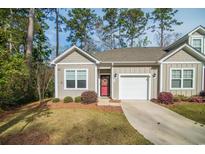 Charming single-story home with a red door, attached garage, and a well-maintained lawn surrounded by mature trees at 164 Vineyard Place # 23, Pawleys Island, SC 29585