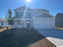 Charming two-story home with a manicured lawn, attached two car garage and traditional curb appeal at 211 Calm Dr., Little River, SC 29566