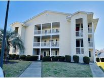 Attractive condo building featuring private balconies, well-kept landscaping, and a clear blue sky at 213 Landing Rd. # F, North Myrtle Beach, SC 29582