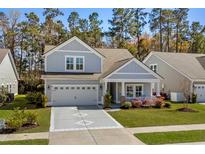Charming two-story home with gray siding, a well-manicured lawn, and an attached two-car garage at 2390 Goldfinch Dr., Myrtle Beach, SC 29577