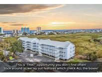 An aerial view of the condo building nestled between the ocean and marsh at 300 Marsh Pl. # 302A, Garden City Beach, SC 29576