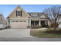 Charming home featuring a two-car garage, well-manicured lawn, and inviting front porch at 4228 Ravenwood Dr., Little River, SC 29566