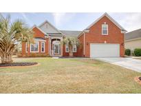 Charming red brick home with a well-manicured lawn and mature palm trees enhancing curb appeal at 432 Highfield Loop, Myrtle Beach, SC 29579