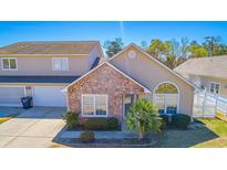 Charming two-story home with stone accents, inviting front yard, and attached garage, offering curb appeal at 4329 River Gate Ln., Little River, SC 29566