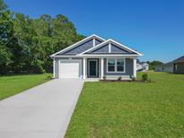 Charming home with gray siding, a well-manicured lawn, and a concrete driveway on a sunny day at 48 Cape Point Dr., Conway, SC 29527