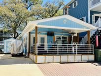 Charming light blue beach house featuring a spacious outdoor patio and appealing coastal design at 6001 - 1268 S Kings Hwy., Myrtle Beach, SC 29575