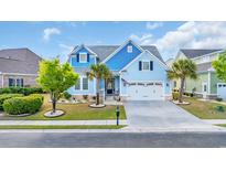 Charming blue two-story home with a well-manicured lawn, palm trees, and a two car garage at 6004 Flowerdale Ct., Myrtle Beach, SC 29579
