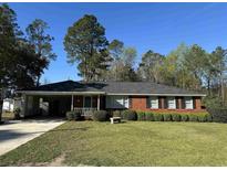 Charming brick ranch-style home with a well-manicured lawn and mature trees in a quiet neighborhood at 61 Lakewood Dr., Andrews, SC 29510