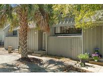 Charming gray home exterior featuring a mature palm tree and lovely landscaping at 7300 Porcher Dr. # 11, Myrtle Beach, SC 29572