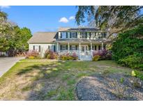 Charming home with a welcoming front porch, a well-maintained lawn, and mature landscaping at 837 Flicker Pl., Murrells Inlet, SC 29576