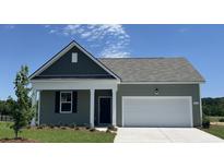 Charming single-story home with a well-manicured lawn, a two-car garage, and lovely curb appeal at 886 Farmers Passage Loop, Loris, SC 29569