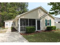 Charming single-story home featuring a screened front porch and well-maintained landscaping at 9972 Conifer Ln., Murrells Inlet, SC 29576