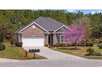 Charming brick home featuring an attached garage, landscaped yard, and a well-manicured lawn at 1112 Raven Cliff Ct., Conway, SC 29526