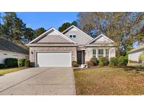 Charming single-story home featuring a brick facade, a two-car garage, and well-maintained landscaping at 1130 Inlet View Dr., North Myrtle Beach, SC 29582