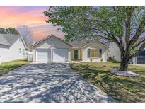 Charming single-story home with a two-car garage, inviting entrance, and mature tree in the front yard at 206 Forest Dr., Longs, SC 29568