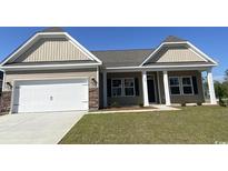 Charming single-story home featuring a two-car garage, covered entry, and manicured lawn at 997 Oak Hollow St., Longs, SC 29568