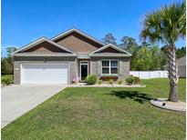 Charming brick home with a well-manicured lawn and a beautiful palm tree, showcasing curb appeal at 112 Rialto Dr., Conway, SC 29526