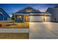 Charming home featuring a two-car garage, yellow door, and manicured lawn at 1279 Safe Haven Dr., Myrtle Beach, SC 29579