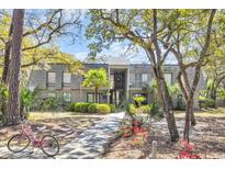 Charming condo with a landscaped yard, trees, and a walkway leading to the entrance at 178 Salt Marsh Circle # 30D, Pawleys Island, SC 29585