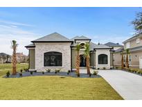 Beautiful two-story home featuring a gray stone facade, well-manicured lawn, and a concrete driveway at 311 73Rd Ave. N, Myrtle Beach, SC 29572