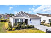 Charming one-story home with manicured lawn, attached garage, and South Carolina state flag at 351 Firenze Loop, Myrtle Beach, SC 29579