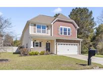 Charming two-story home boasts a well-manicured lawn, attached two-car garage, and inviting curb appeal at 3659 White Wing Circle, Myrtle Beach, SC 29579